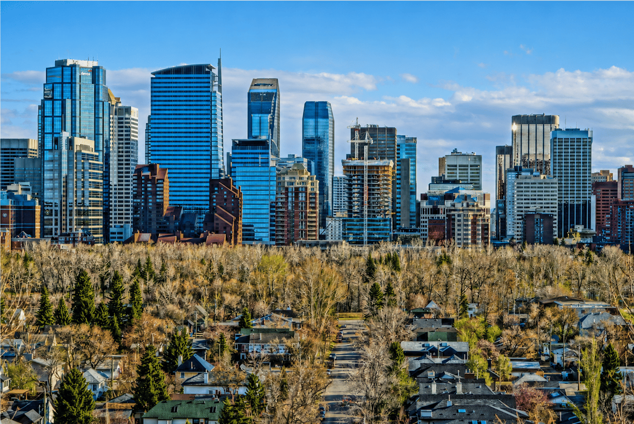 Calgary skyline with downtown skyscrapers above a tree lined residential neighbourhood