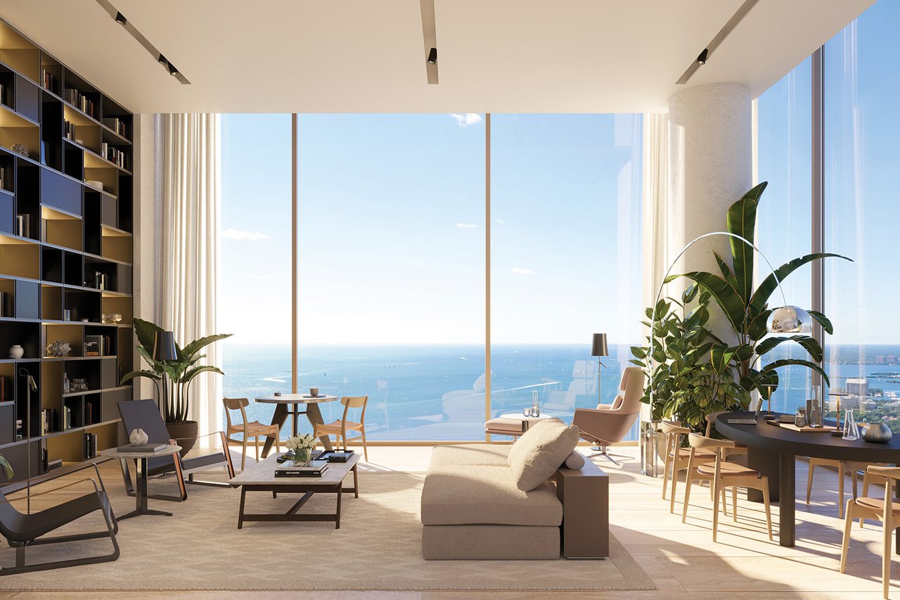 High-rise living room with floor-to-ceiling ocean-view windows, built-in shelves, and a light sectional sofa.