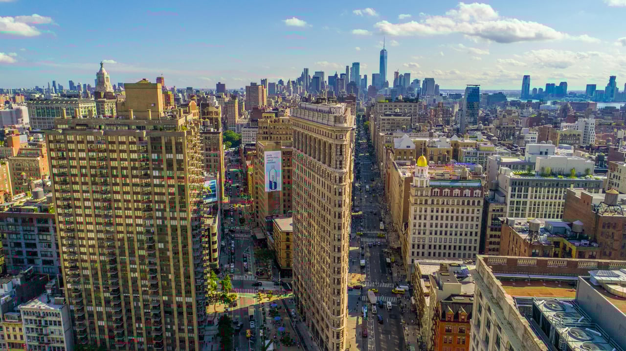 The iconic Flatiron Building in New York City, showcasing its unique triangular design that gave the neighborhood its name.