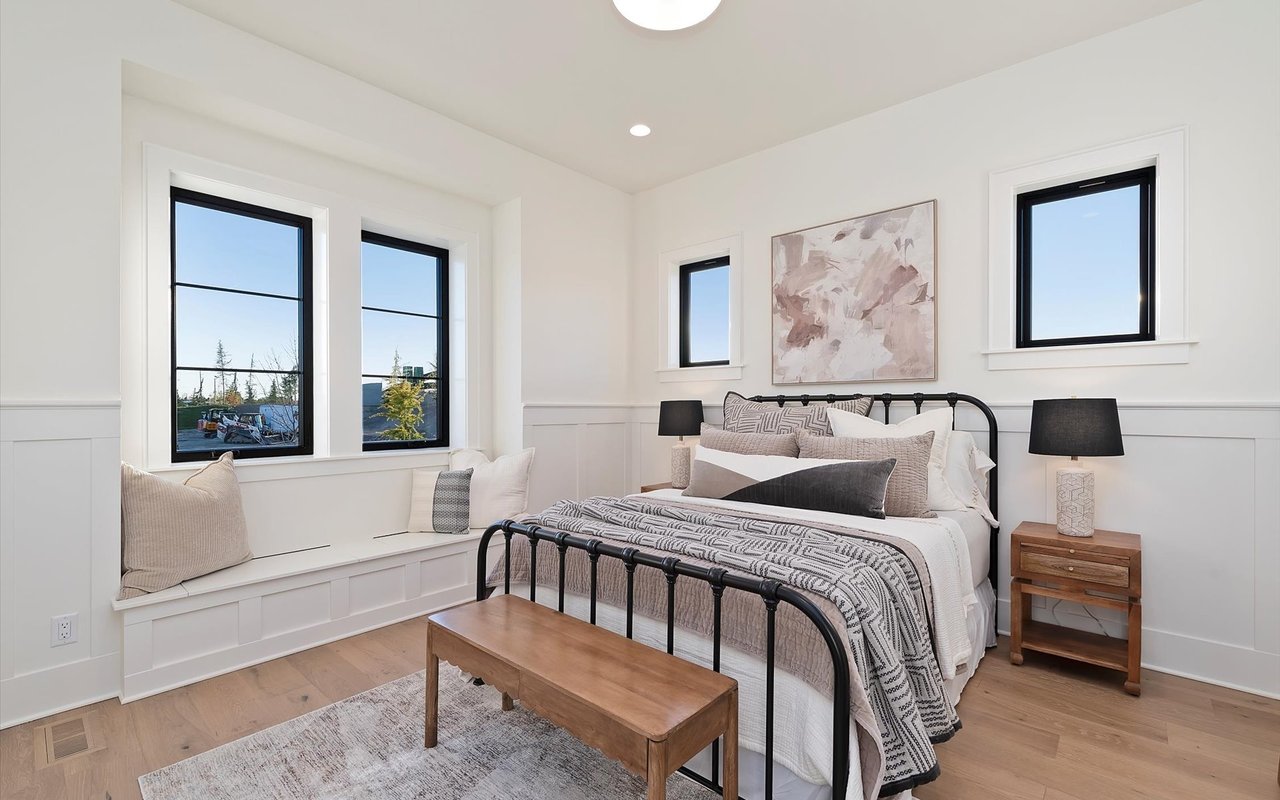 Upstairs guest junior suite featuring a bench seat under two black steel windows and wainscoting