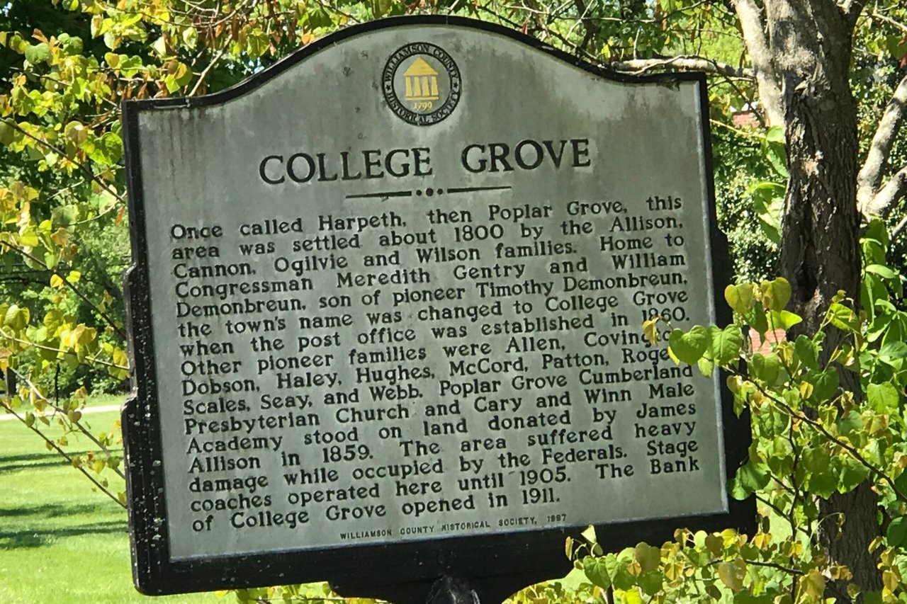 College Grove historical marker describing the town’s settlement, surrounded by leafy trees.