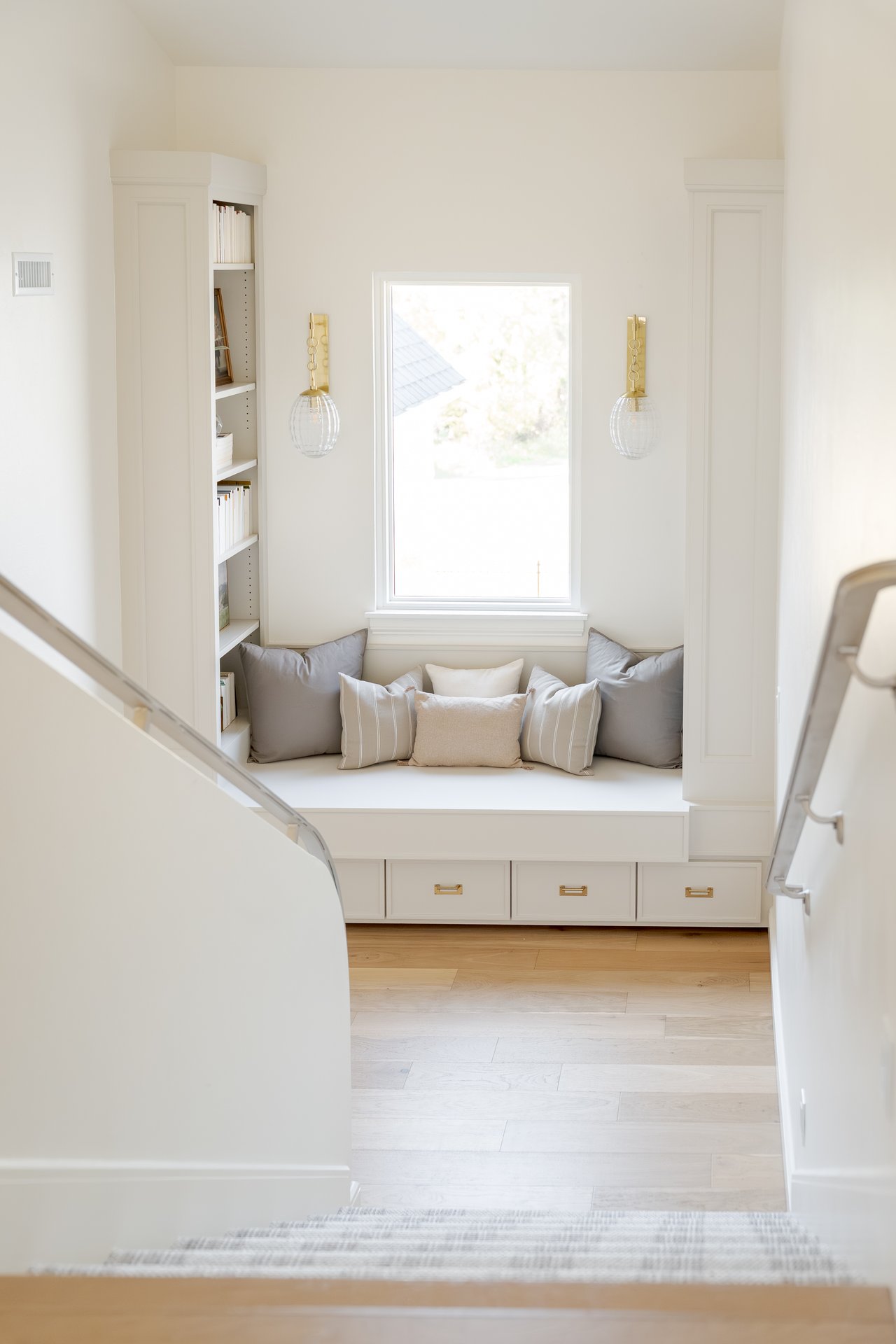 nviting stair landing in an Edmond luxury home featuring a custom built-in daybed, bookshelves, and soft lighting — a perfect cozy nook that adds charm and character to the home’s design.