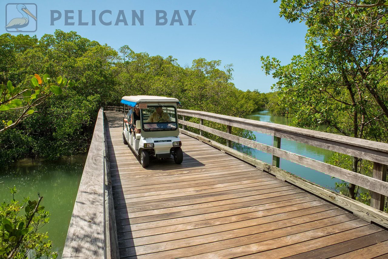 Pelican Bay private tram driving along scenic wooden boardwalk through mangrove preserve in Naples Florida