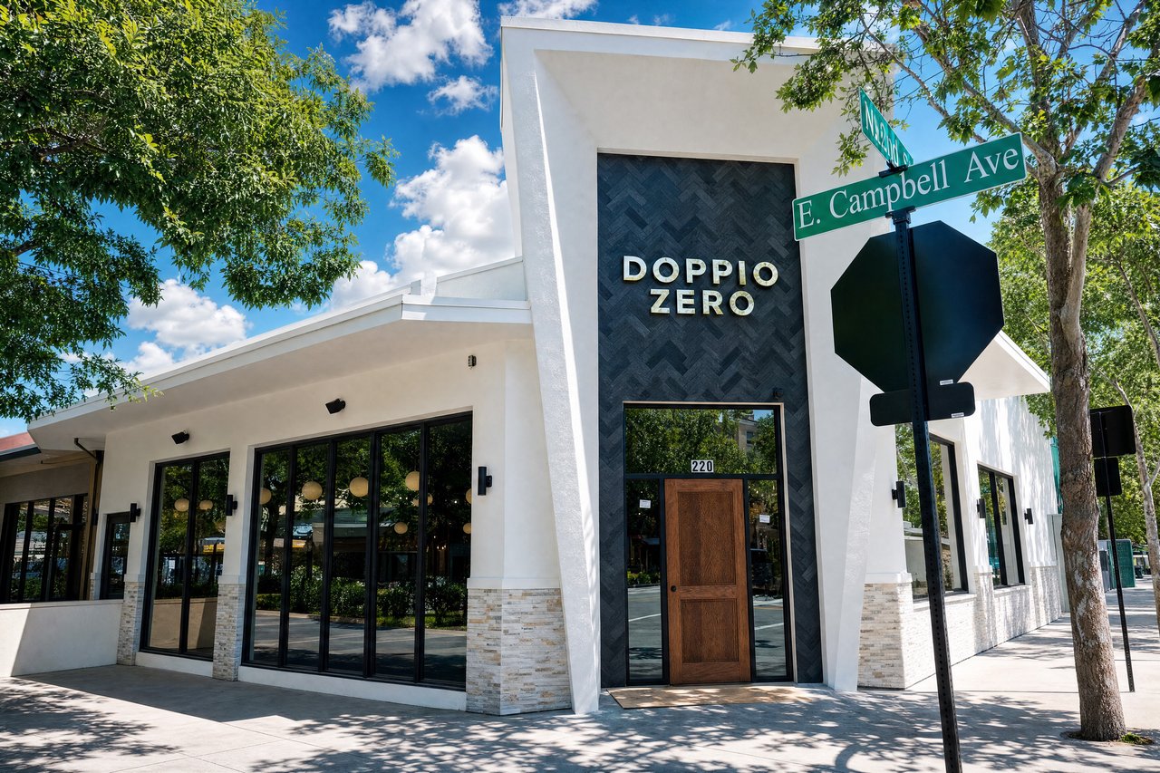 Doppio Zero restaurant exterior with a tall dark entry facade and large black-framed windows.
