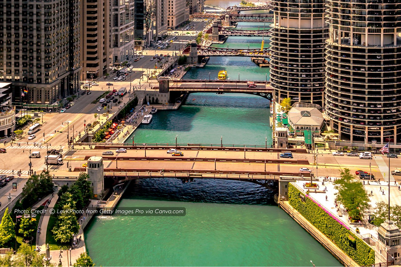 Chicago River winding between downtown high-rises, with several bridges crossing the water.
