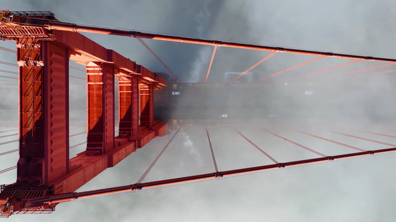 Aerial view of the Golden Gate Bridge tower piercing through morning fog, the daily commute corridor for Apple shuttle riders crossing between Marin and San Francisco.
