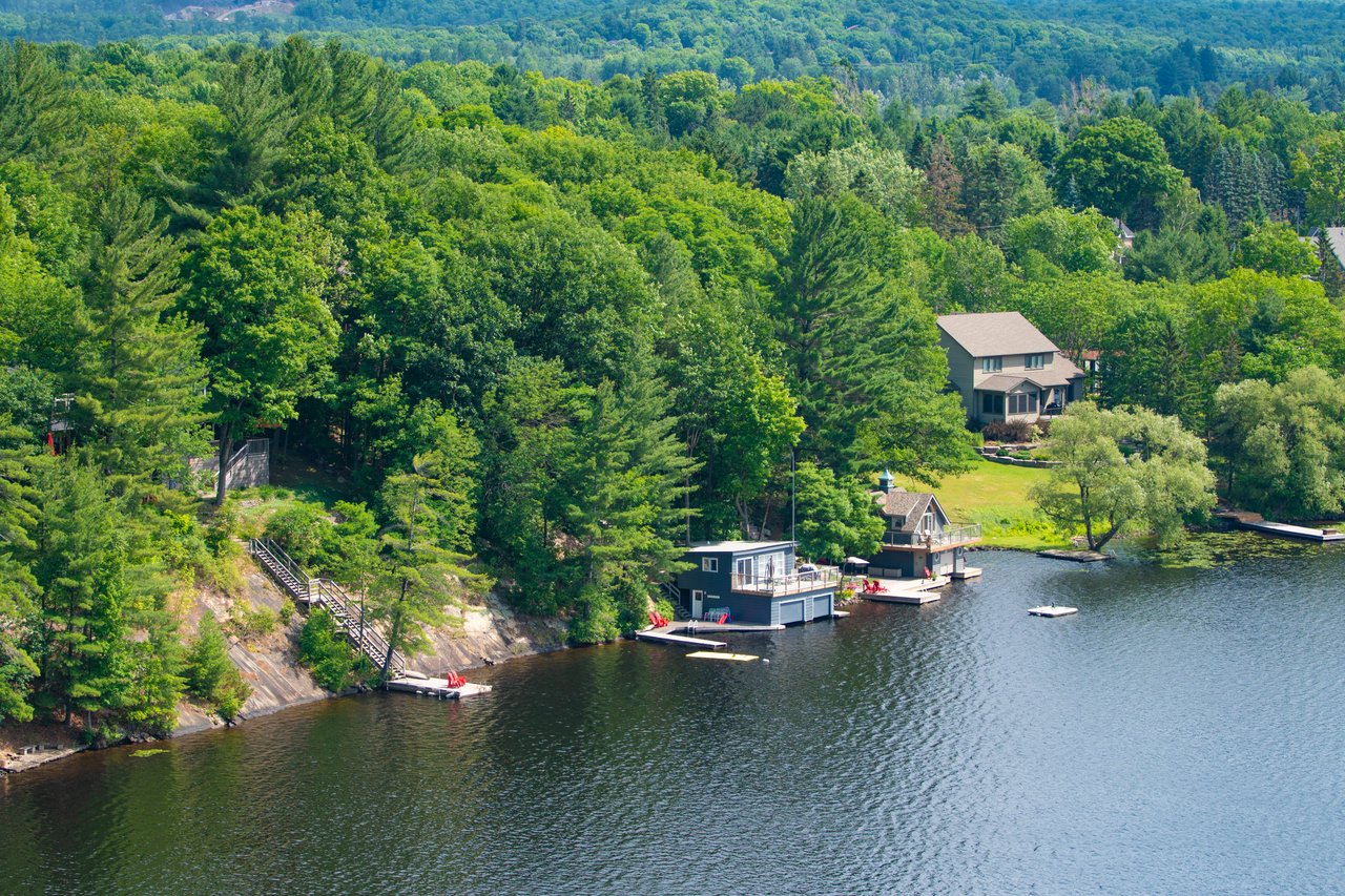 View of cottages along a picturesque shoreline between Huntsville and the Almaguin Highlands in Ontario cottage country.