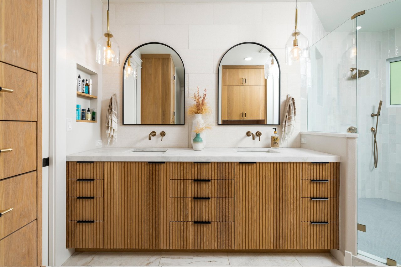 Primary bathroom with dual vanities and walk-in shower