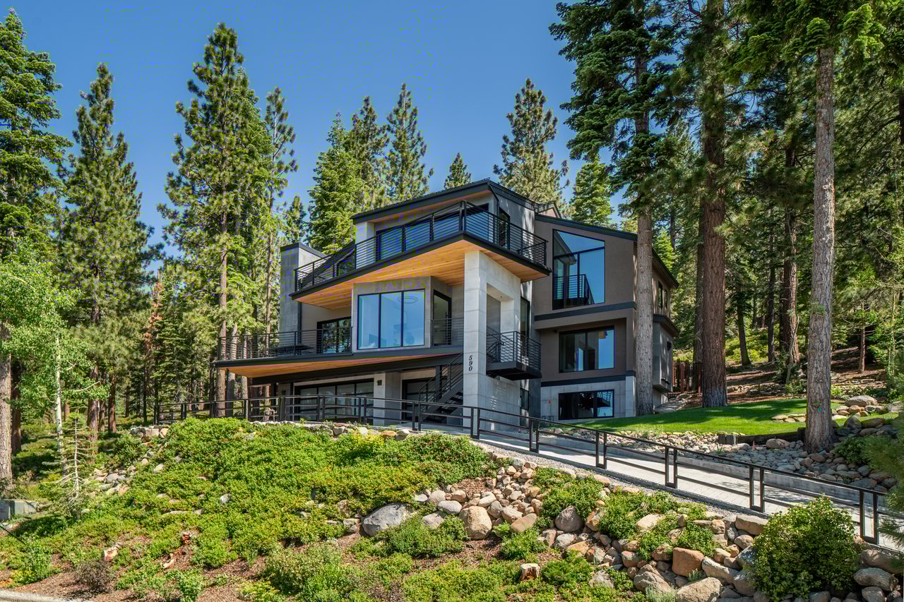 A stylish outdoor deck in Lake Tahoe with seating, fire pit, and lake views