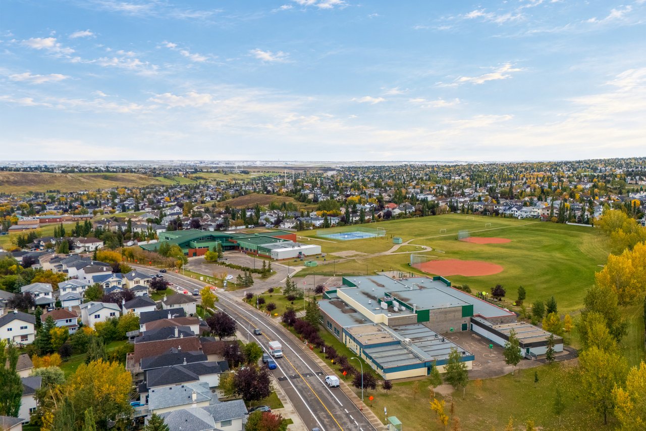 Aerial view of a Calgary neighborhood, school campus, and sports fields in autumn.