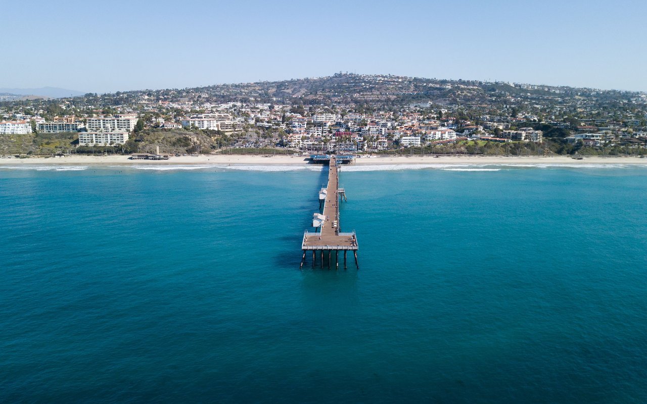San Clemente coastline and hillside town, viewed over the ocean with the pier centered.
