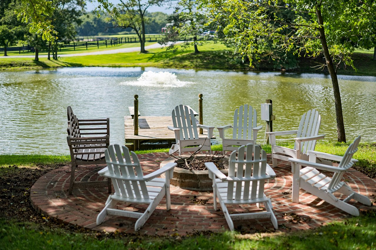 Firepit overlooking the pond with equestrian center int he background