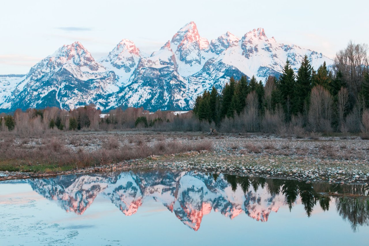View of the Grand Teton Mountains near Jackson Hole, Wyoming with reflection in water — popular backdrop for mountain homes and real estate in the area
