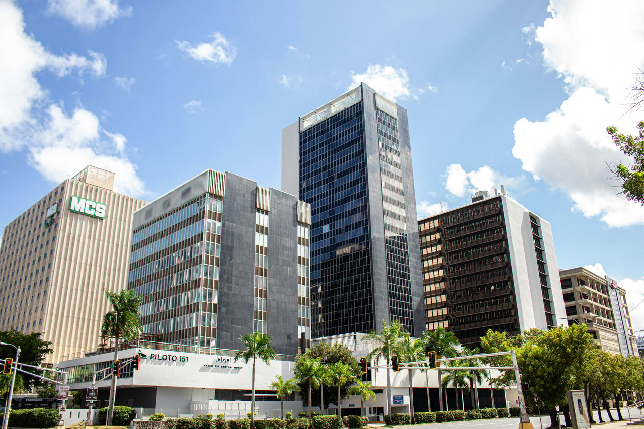 The Hato Rey Financial District skyline with modern office buildings, including MCS, Piloto 151, and other high-rises surrounded by palm trees