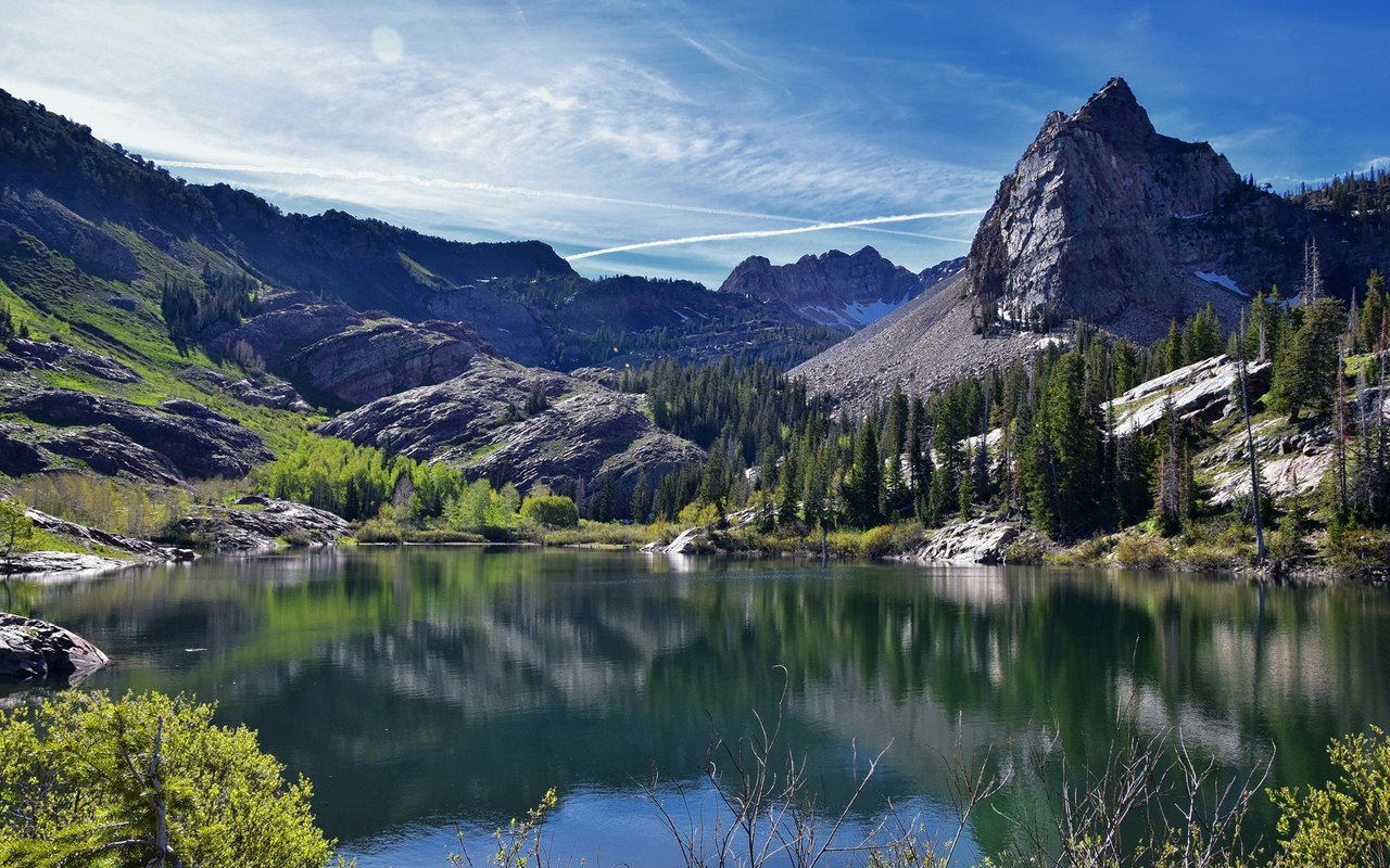 Alpine lake reflecting rocky mountain peaks and evergreen forest