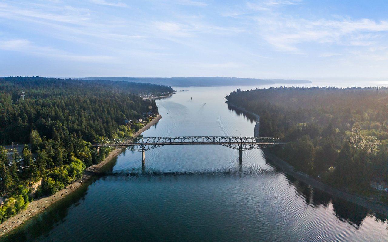 Agate Pass Bridge crosses calm water between wooded shorelines.