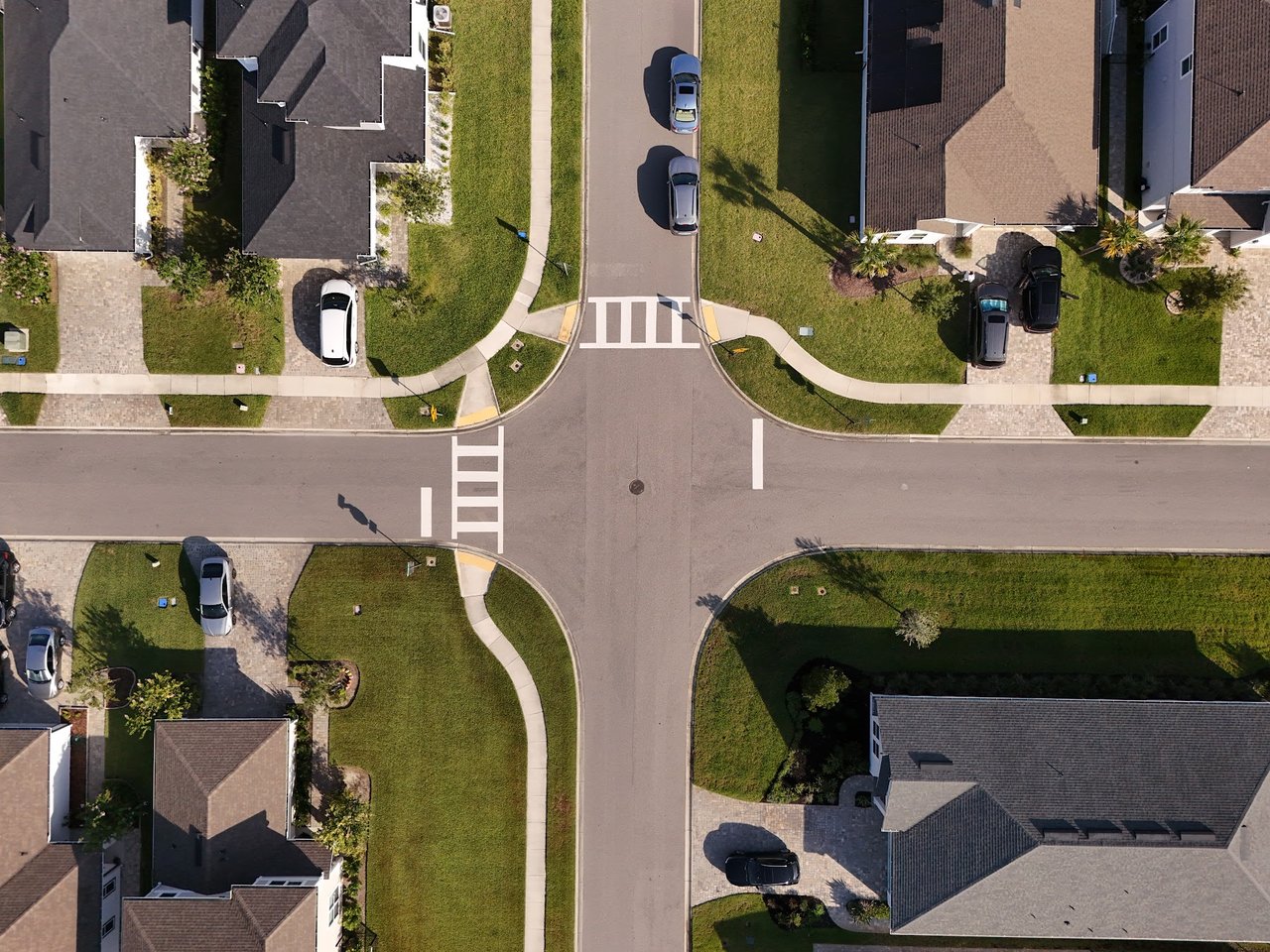 Aerial view of Silverleaf Village homes surrounding a four-way intersection with crosswalks and parked cars.