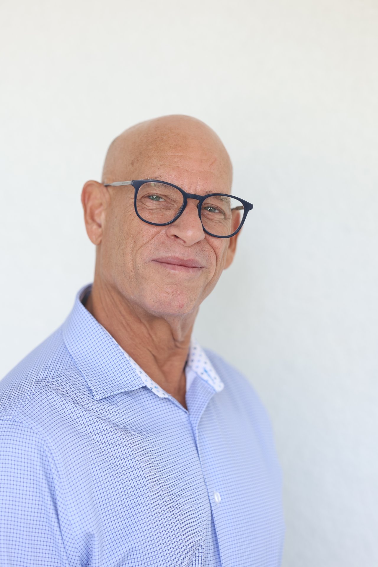 Marc Gresack wearing dark blue glasses and a light blue checked shirt