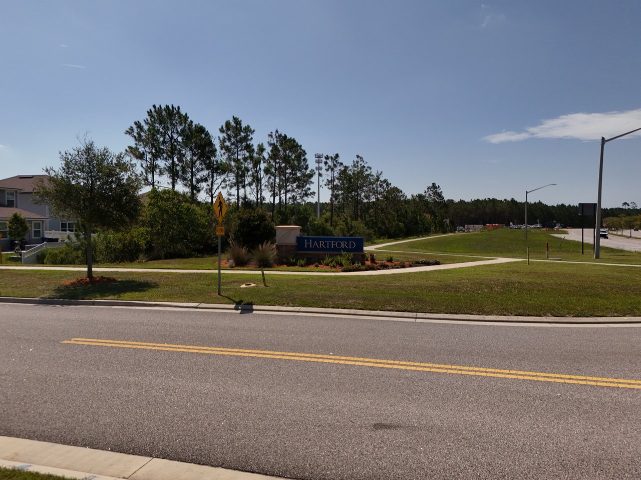 Hartford community entrance sign beside a landscaped sidewalk and roadway.