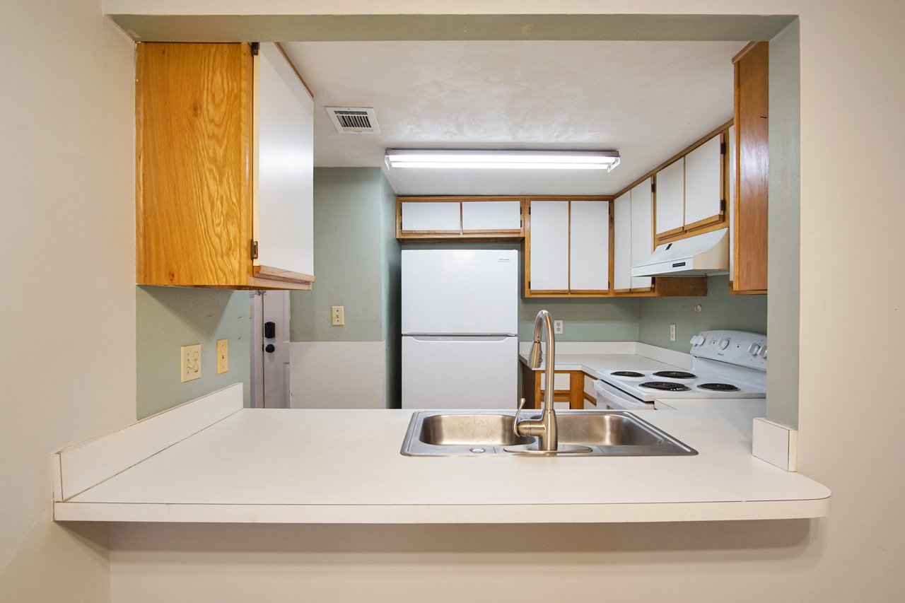 A kitchen featuring a sink and a refrigerator, showcasing a clean and functional cooking space.