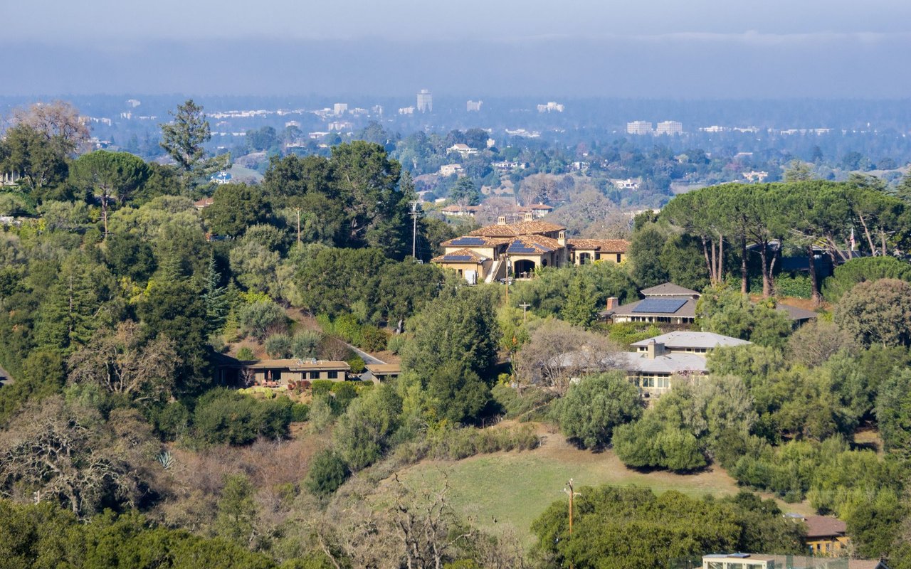 Los Altos neighborhood with wooded hills, homes, and a hazy distant skyline.