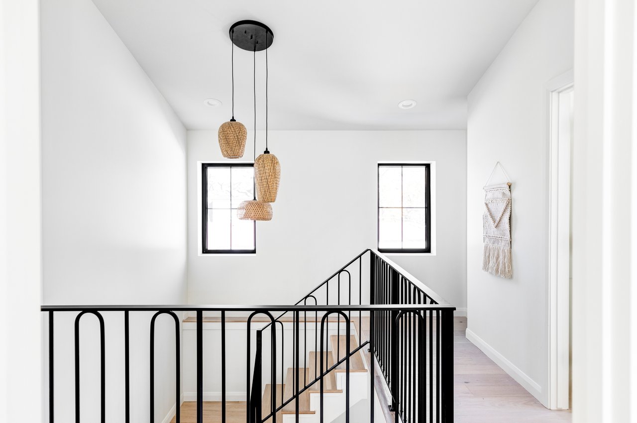 Stairwell view from 2nd floor with 3 pendant wicker light fixture above