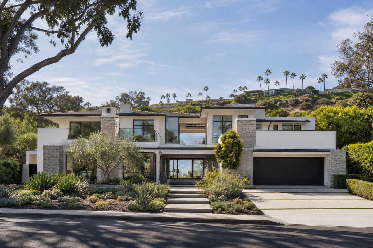 Contemporary two-story home with stone accents, broad windows, and landscaped grounds.