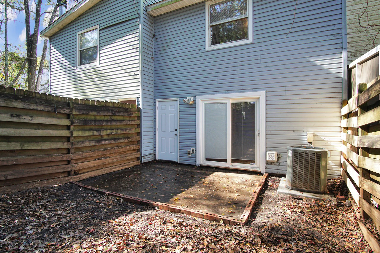 A small backyard featuring a wooden fence and a door, creating a cozy and private outdoor space.