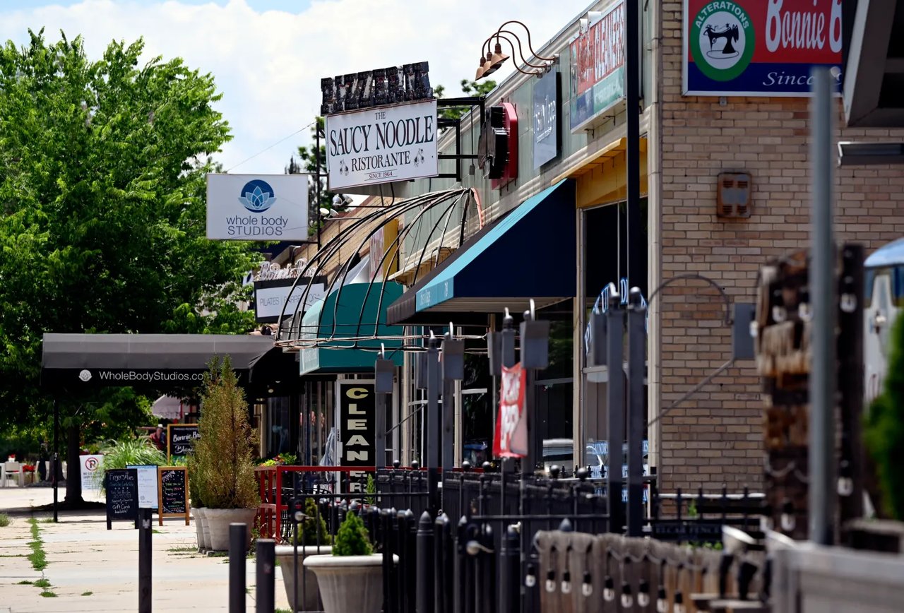 Bonnie Brae storefronts, including The Saucy Noodle Ristorante and Whole Body Studios, along a tree-lined sidewalk.