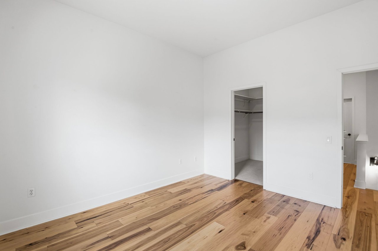 Upstairs hallway with hardwood floors, built-in closet with shelving, and recessed lighting