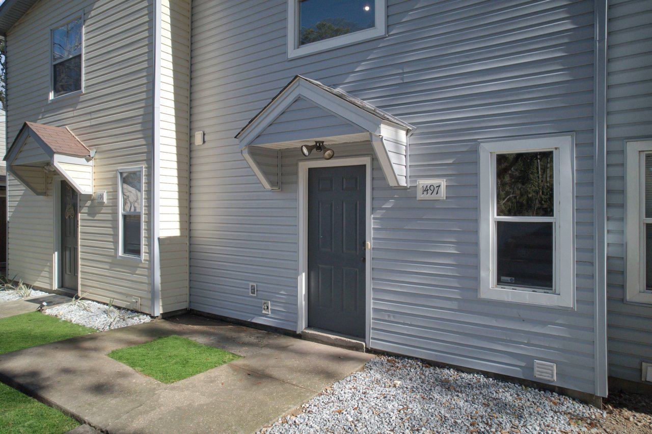 A small grassy area adjacent to a house, providing a serene outdoor space for relaxation and enjoyment.