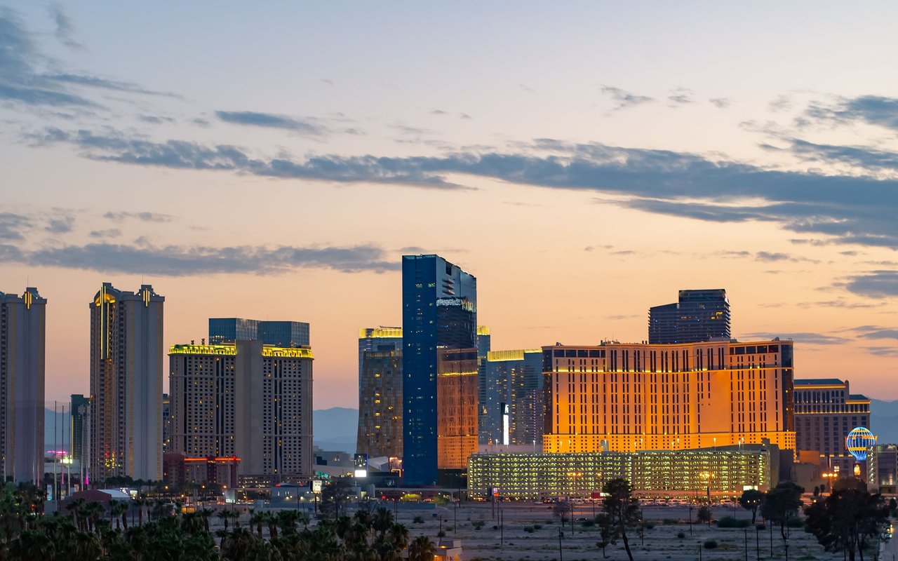 Las Vegas Strip skyline at dusk, with illuminated hotel towers and desert foreground.
