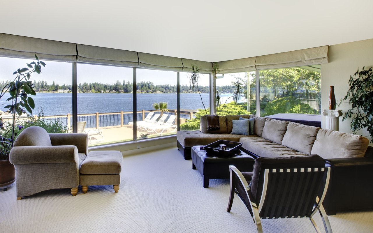 Lakefront living room with floor-to-ceiling windows, a sectional sofa, and a view of the water.