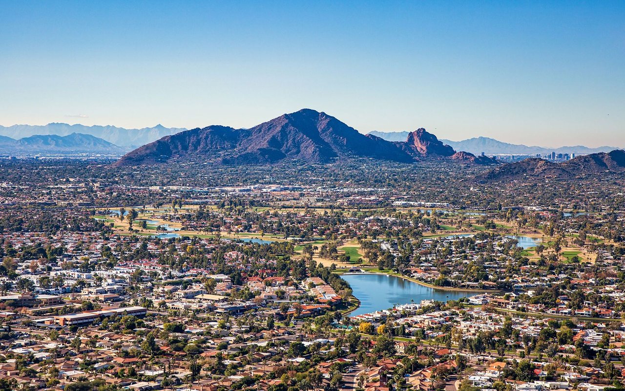 Scottsdale homes, golf courses, and a lake spread beneath Camelback Mountain.
