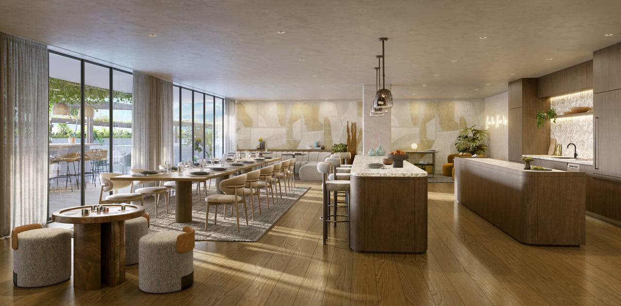 Open-plan dining room and kitchen with a long table, wood island, and floor-to-ceiling windows.