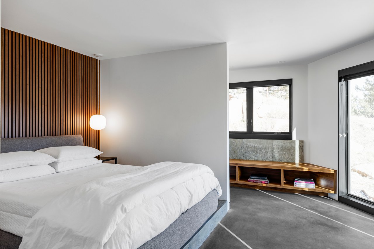 Minimalist Boulder bedroom with wood slat accent wall, built-in corner bookshelf, and mountain views