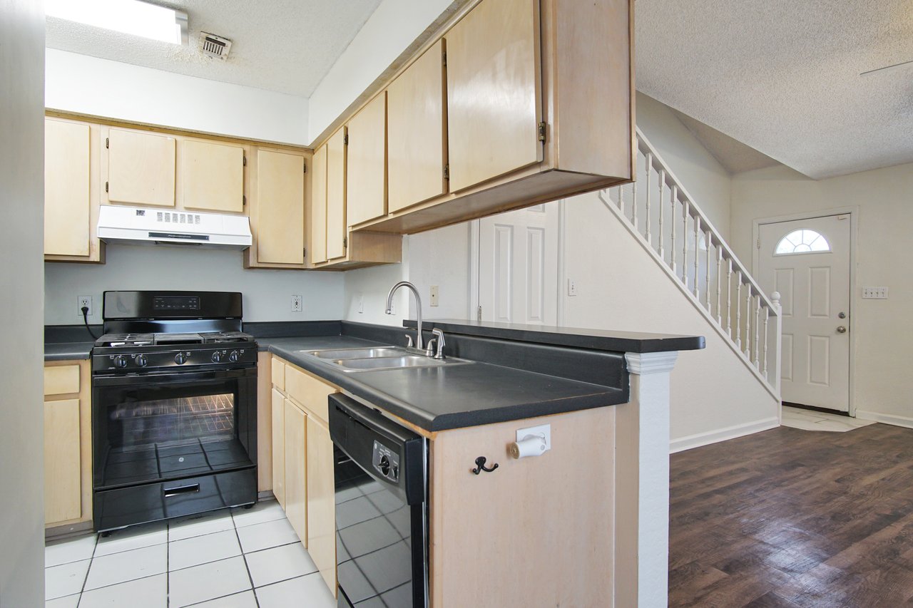 A modern kitchen featuring a stove, refrigerator, and sink, showcasing a functional and organized cooking space.