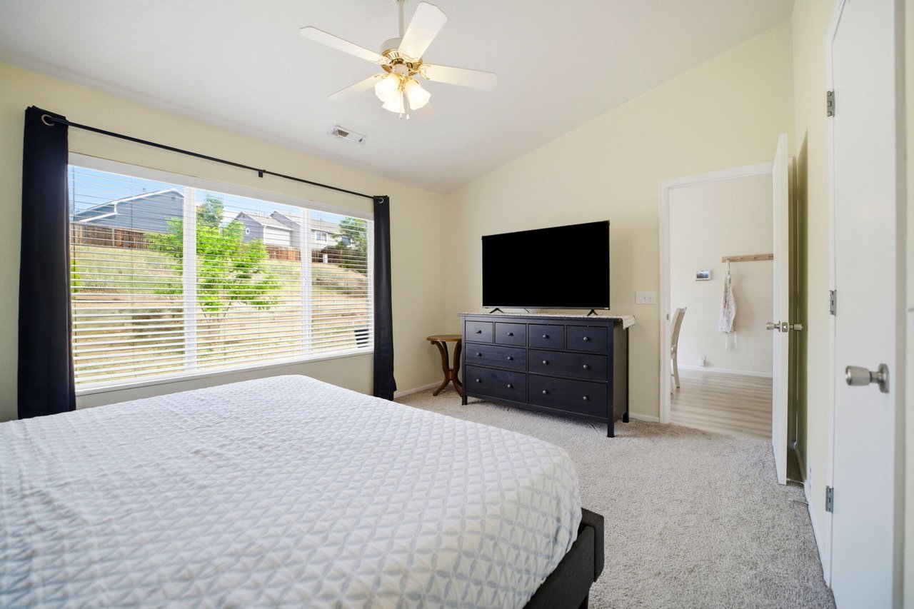 Primary Bedroom with vaulted ceilings looking out to massive yard and patio area