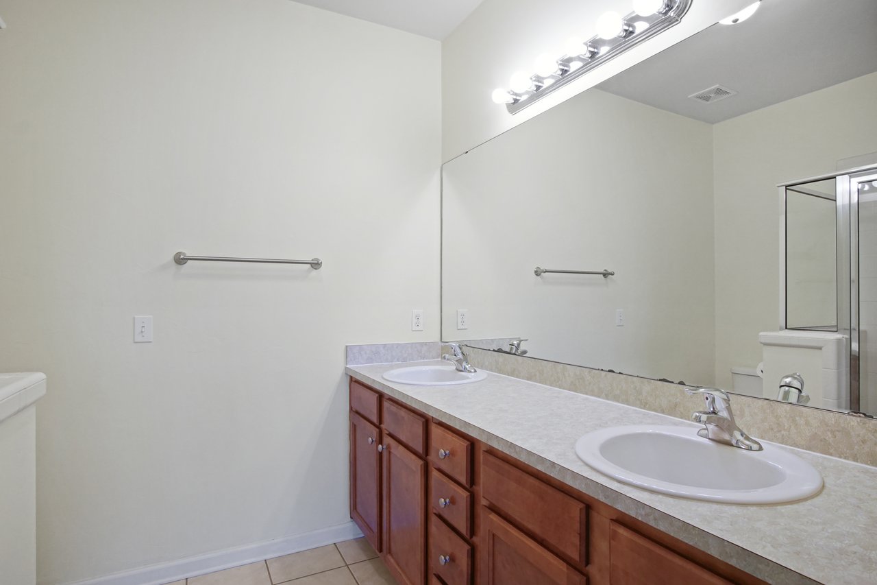 Primary bathroom at 5441 Hampton Hill Circle, Tallahassee, Florida 32311 featuring dual sinks, large mirror, and walk-in shower.
