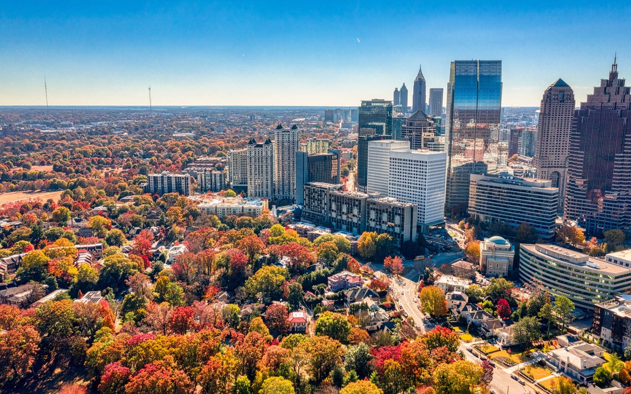 Aerial view of Midtown Atlanta’s skyline above colorful autumn trees.
