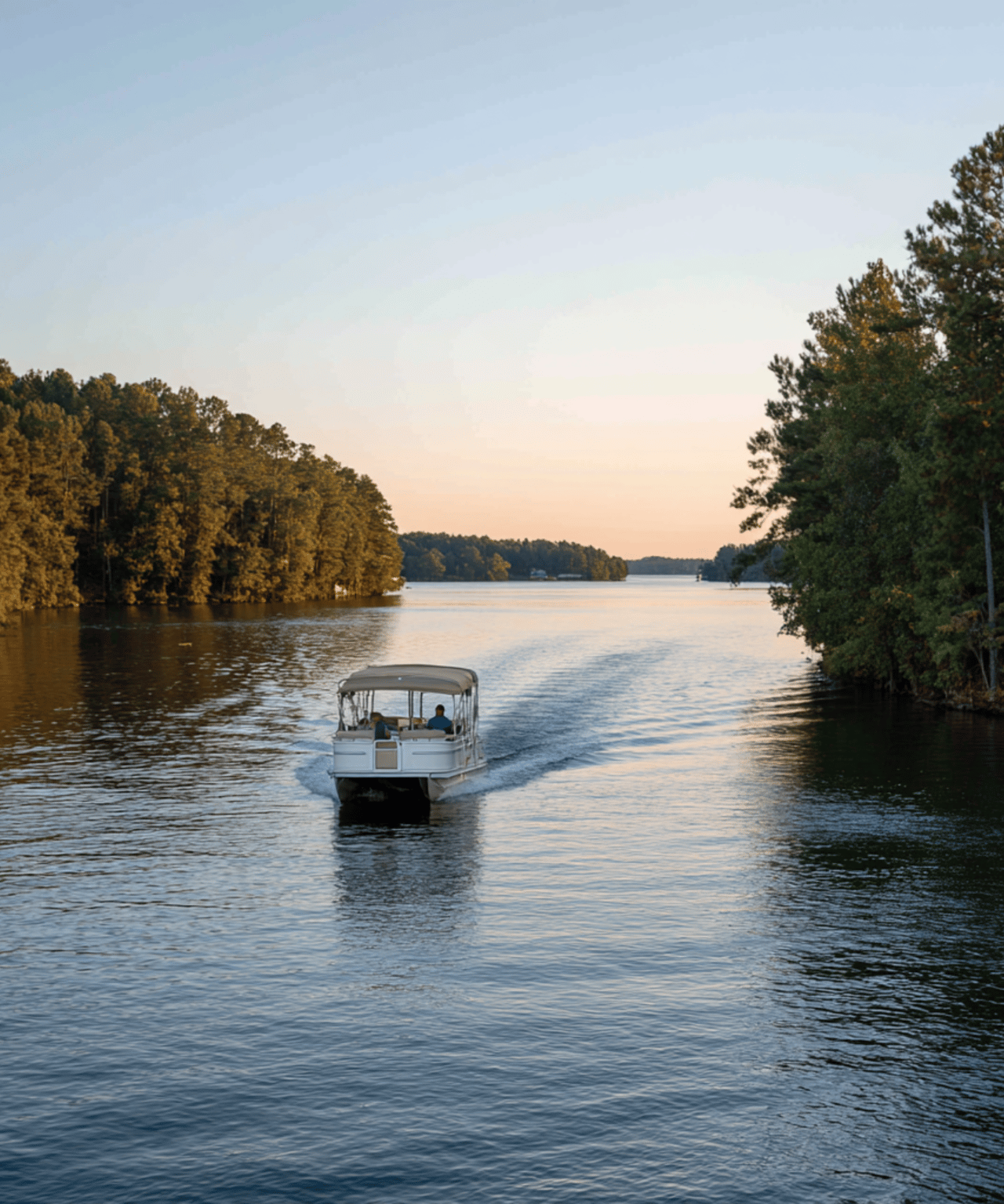Boat cruising between wooded shorelines on a calm lake