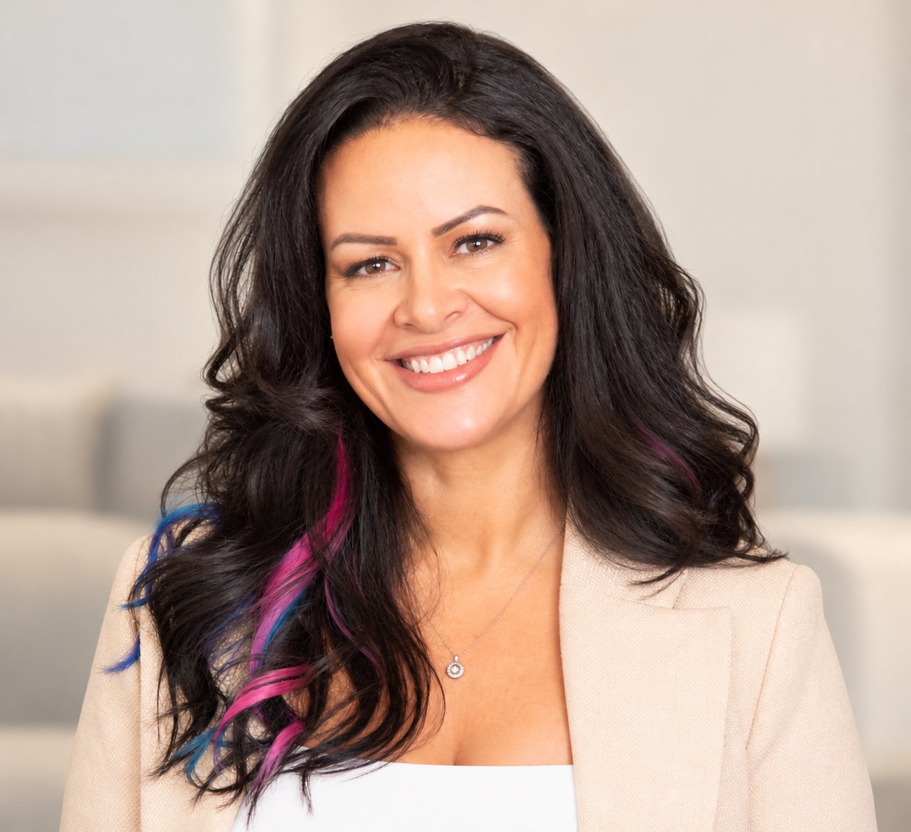 Cortes, smiling real estate agent with long dark hair streaked blue and pink.