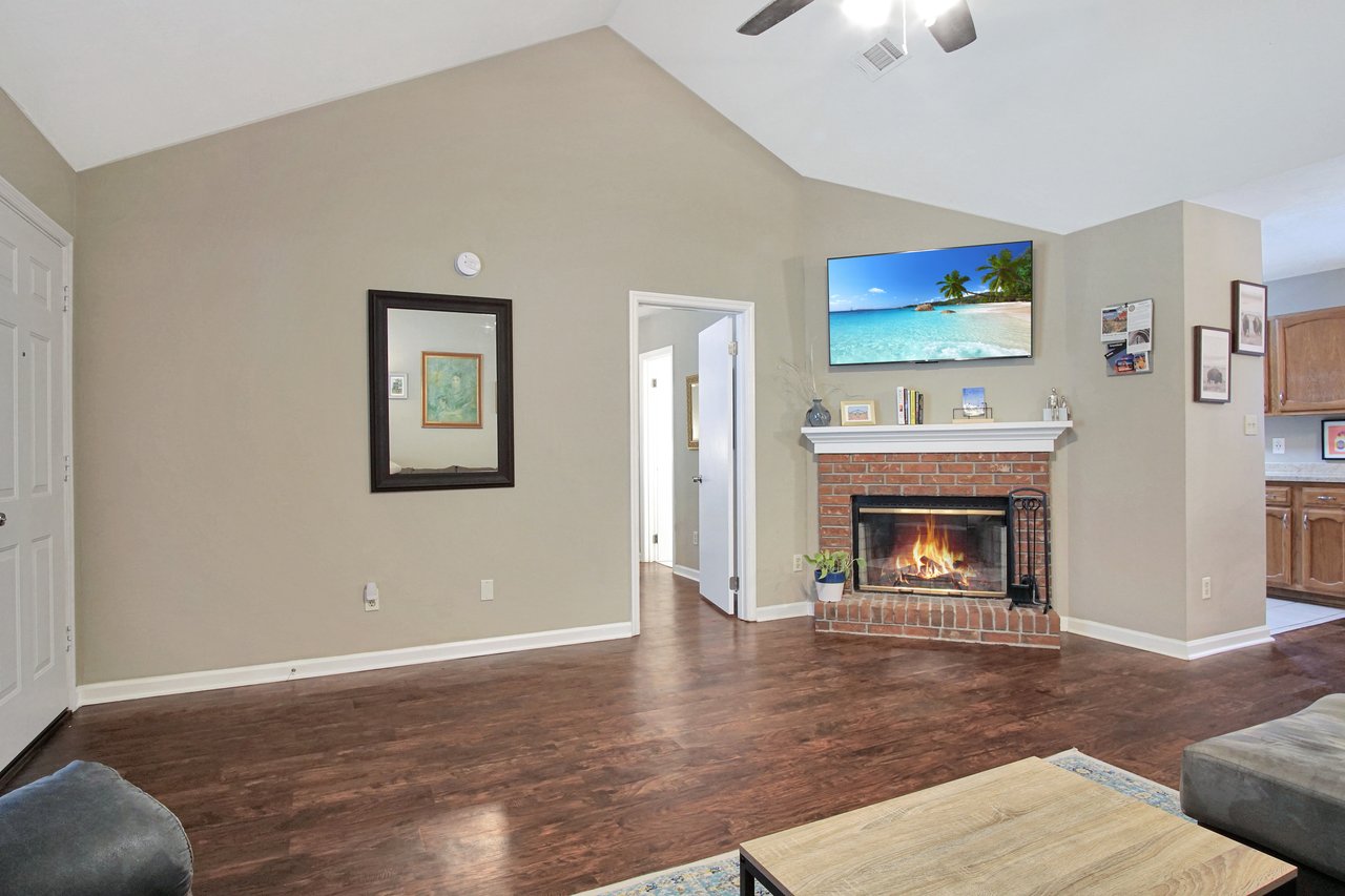 A cozy living room featuring a fireplace and a television, creating a warm and inviting atmosphere for relaxation.