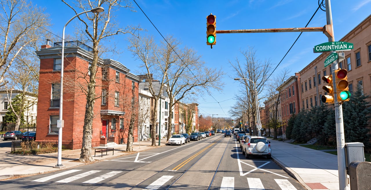Fairmount street with brick rowhouses, trolley tracks, and signs for Corinthian Avenue and Girard Avenue.