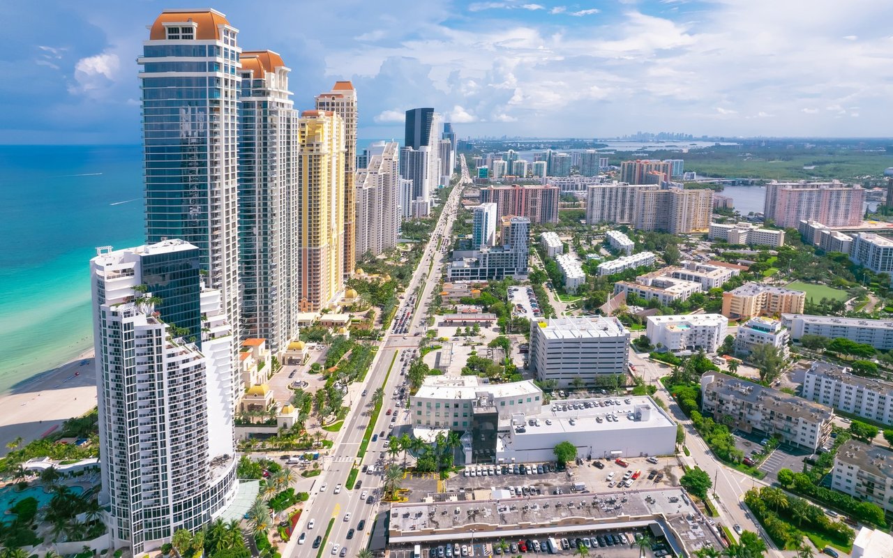 Aerial view of Park Shore beachfront towers, Gulf shoreline, and Naples high-rises.