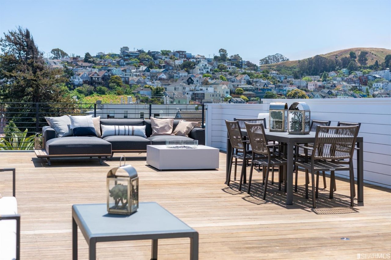 Rooftop terrace with outdoor dining and seating overlooking the neighborhood