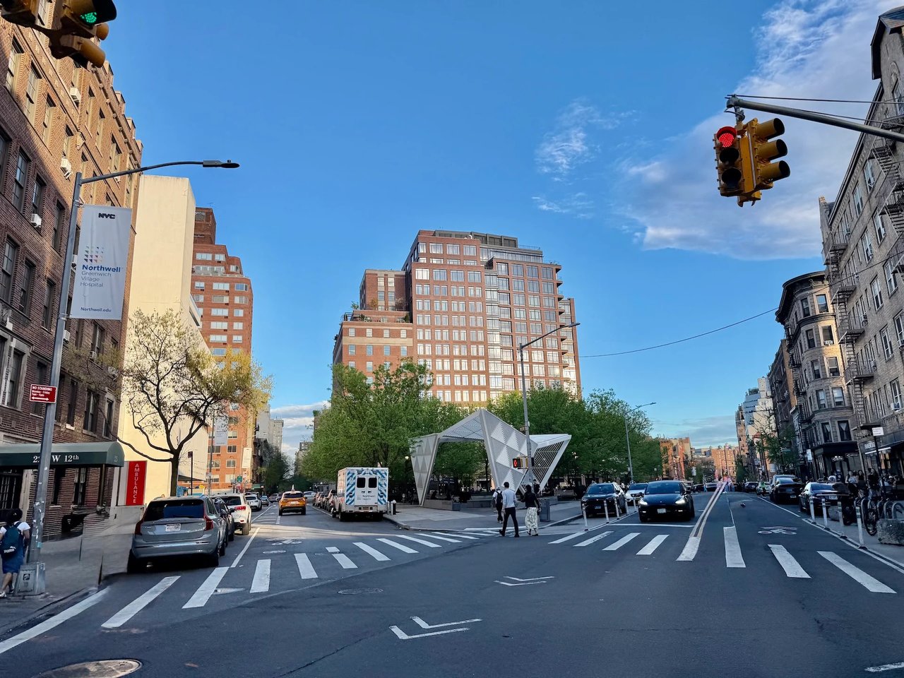 West 12th Street intersection with a white pavilion, leafy plaza, and surrounding New York City buildings.