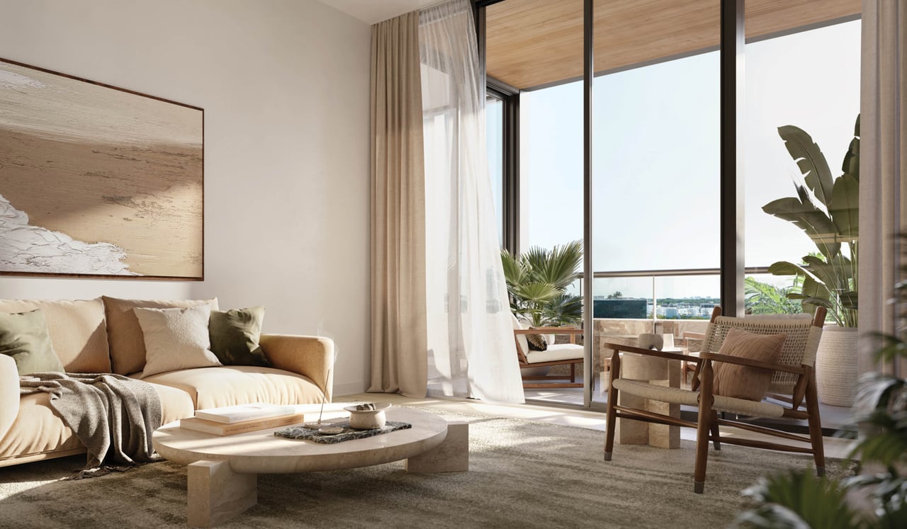 Furnished living room with a cream sofa and floor-to-ceiling windows opening onto a plant-filled balcony.