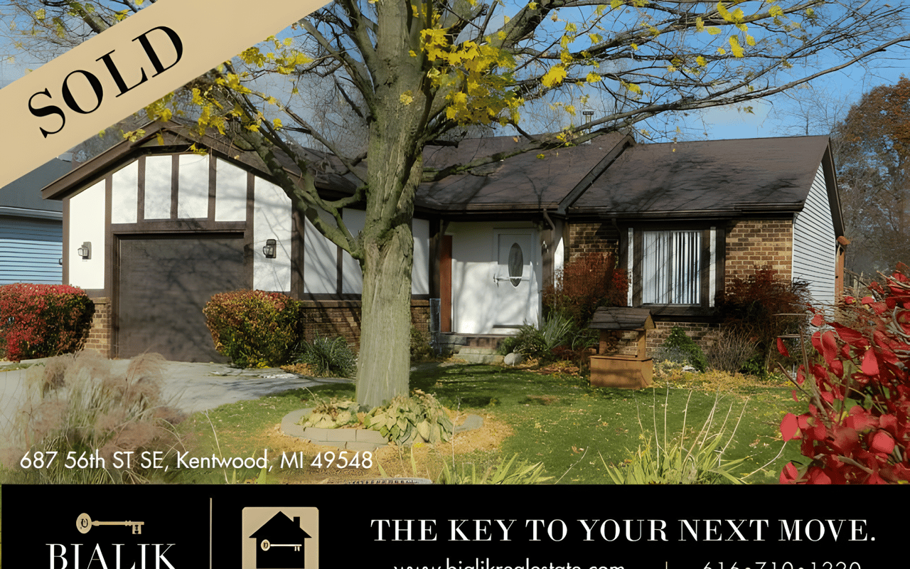 Sold Kentwood home with brick facade, attached garage, and large autumn tree in the front yard.