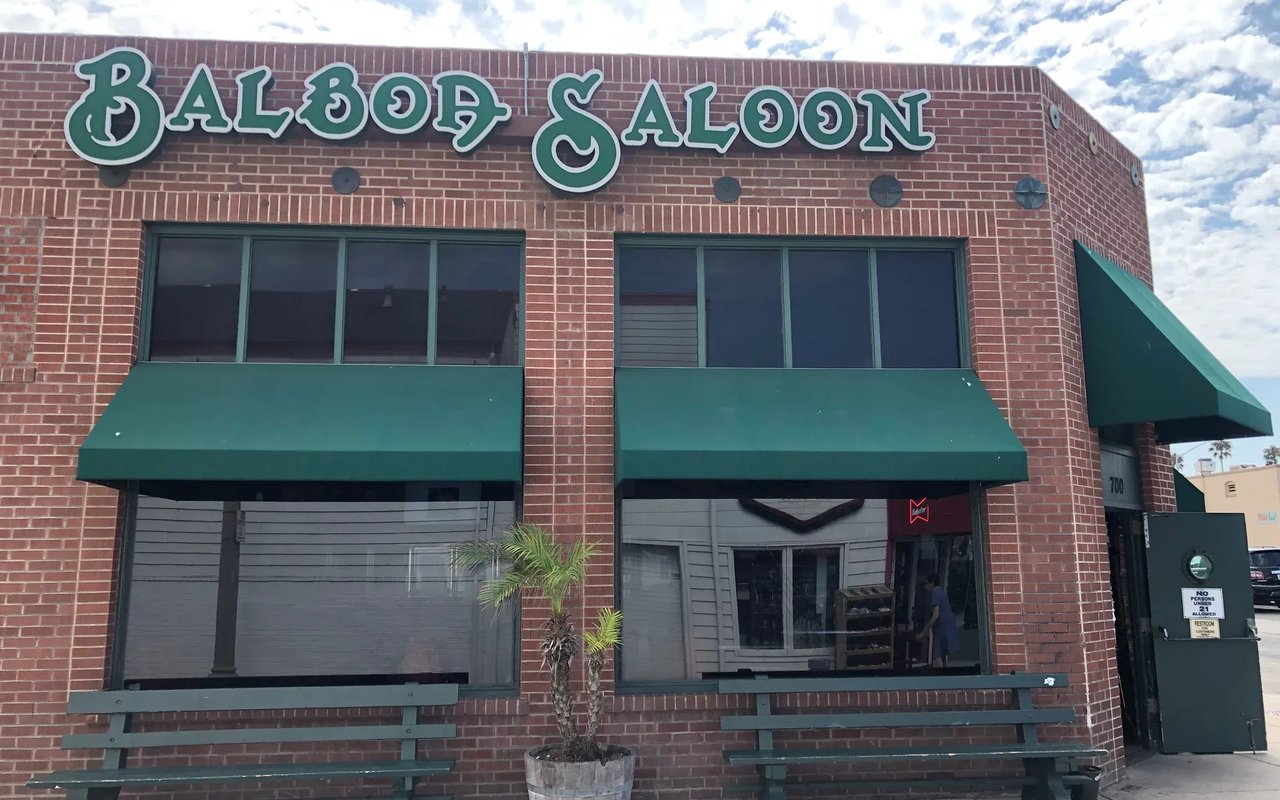 A classic brick building with green awnings and a sign above the door. The mood is nostalgic and rustic.